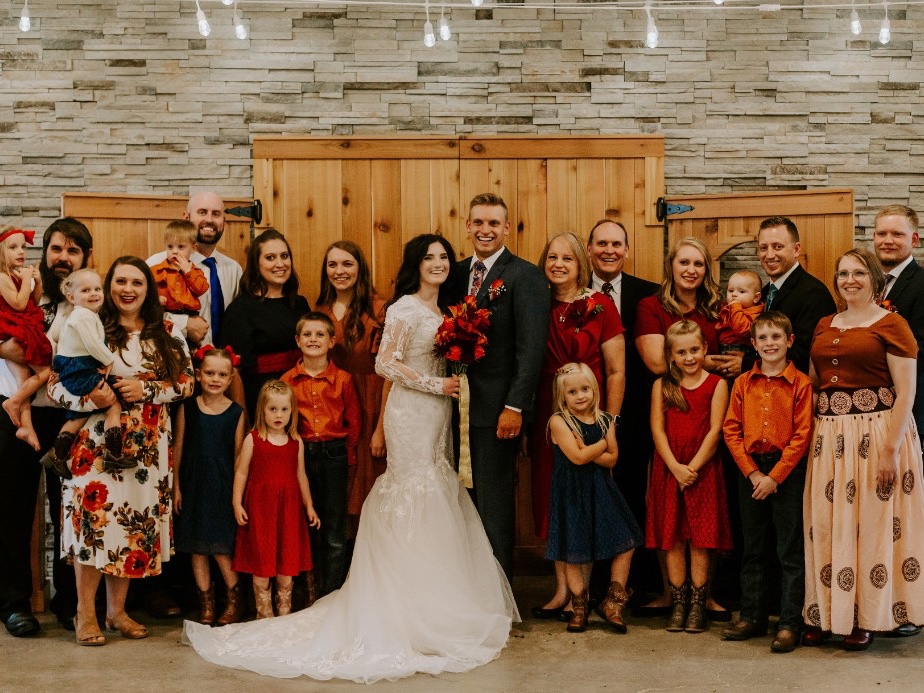 Wedding party indoors against the lodge stone wall